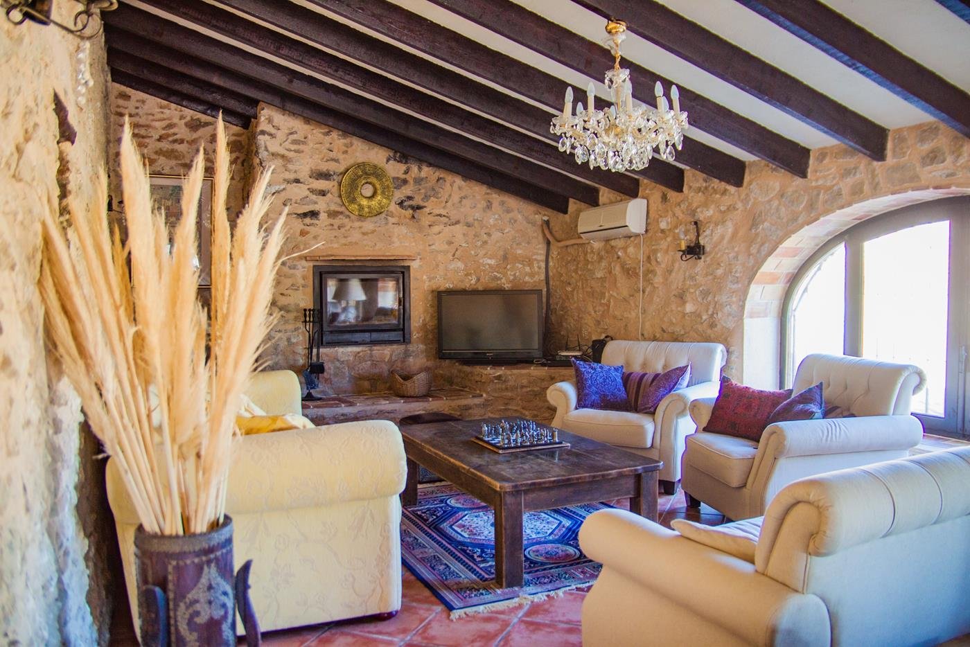 Rustikales Natursteinwohnzimmer mit Kamin und Kristalllüster - Zeitlose Eleganz trifft mediterranes Flair Rustikales Natursteinwohnzimmer mit Kamin und Kristalllüster - Zeitlose Eleganz trifft mediterranes Flair