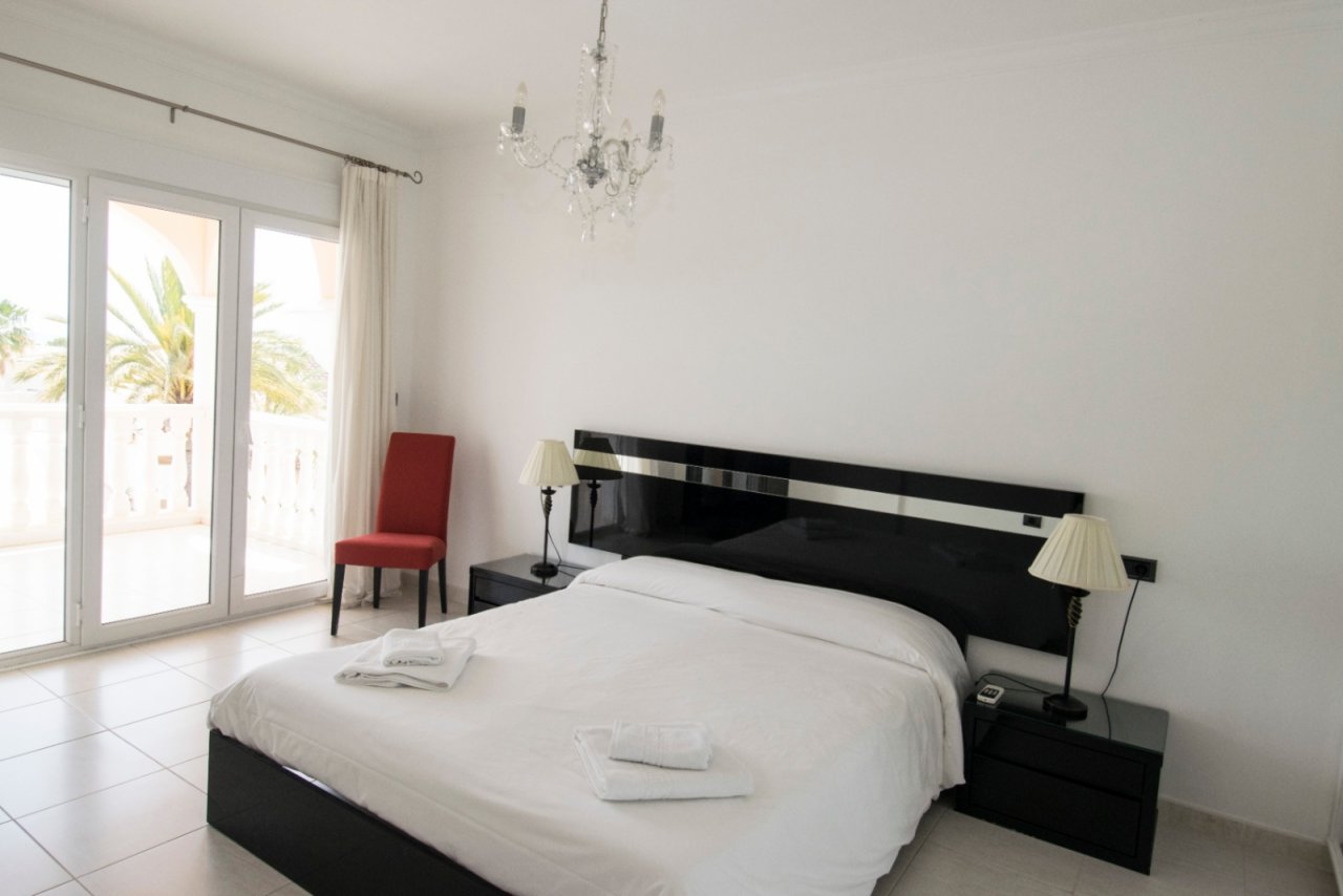 Lichtdurchflutetes Schlafzimmer mit Palmen-Ausblick und elegantem Design Lichtdurchflutetes Schlafzimmer mit Palmen-Ausblick und elegantem Design