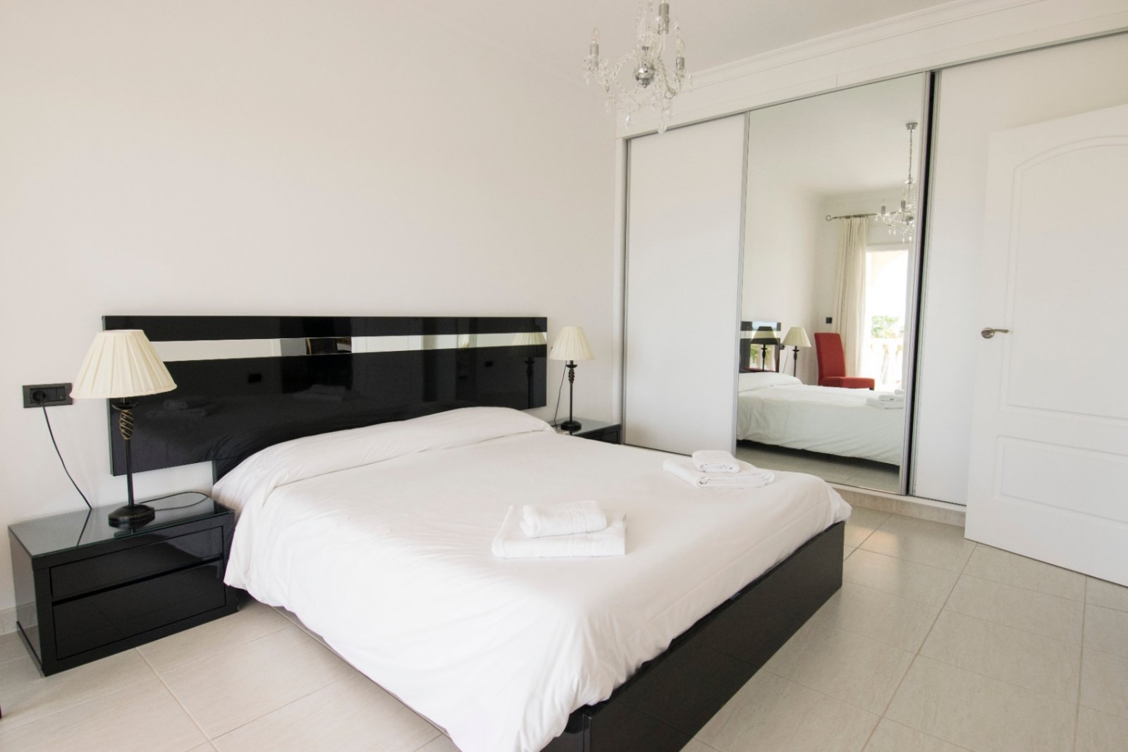 Lichtdurchflutetes Schlafzimmer mit eleganter Spiegelschrank-Front und hochwertigem Designerbett in zeitloser Schwarz-Weiß-Komposition Lichtdurchflutetes Schlafzimmer mit eleganter Spiegelschrank-Front und hochwertigem Designerbett in zeitloser Schwarz-Weiß-Komposition