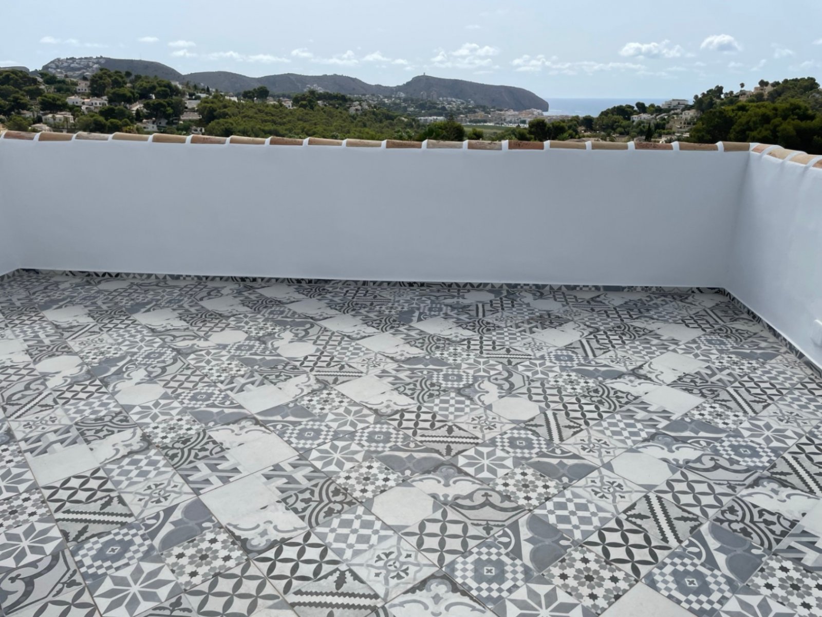 Panorama-Dachterrasse mit mediterraner Zementfliesen-Optik und atemberaubender Meerblick-Perspektive Panorama-Dachterrasse mit mediterraner Zementfliesen-Optik und atemberaubender Meerblick-Perspektive