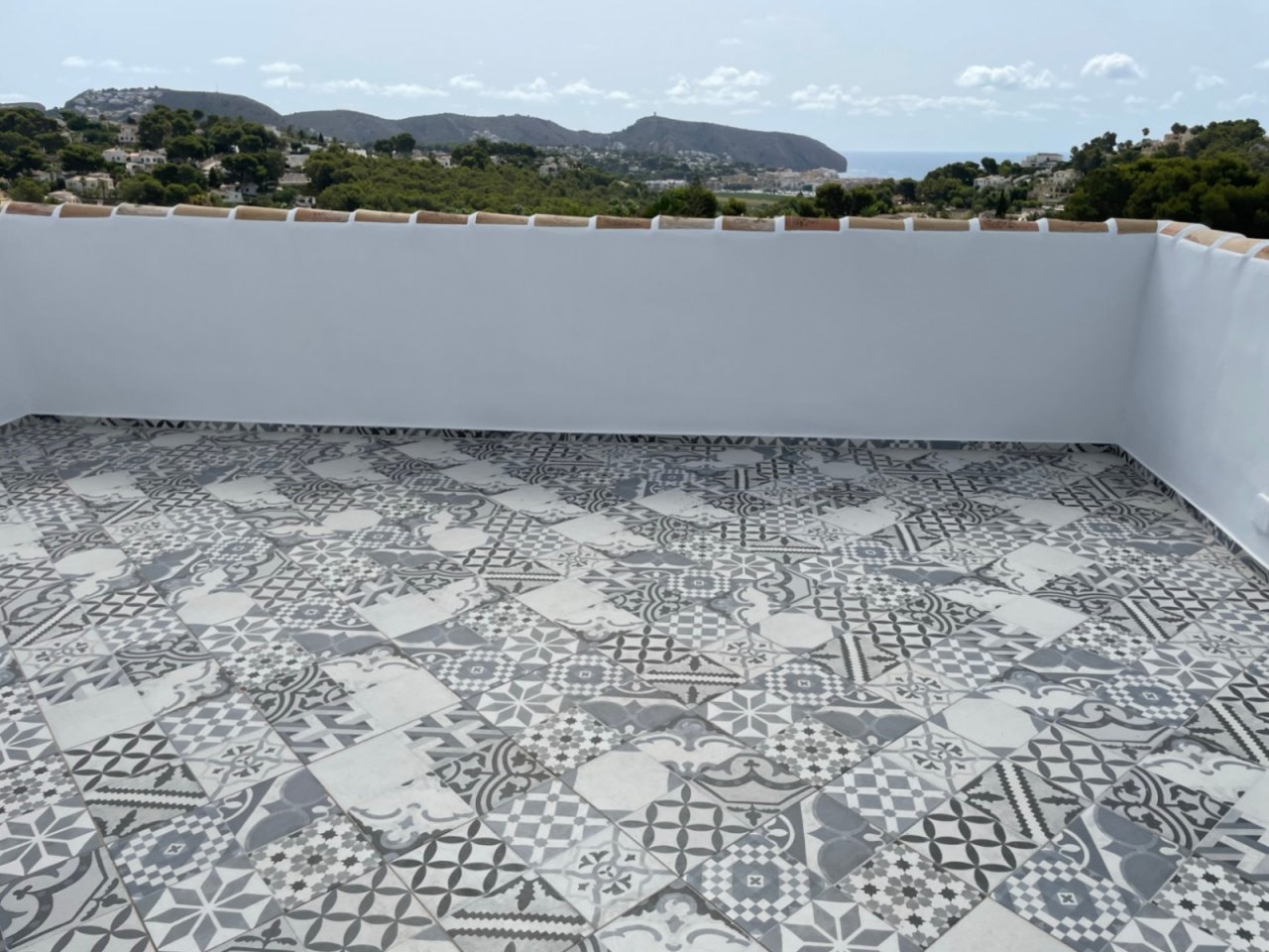 Panorama-Dachterrasse mit mediterraner Zementfliesen-Optik und atemberaubender Meerblick-Perspektive Panorama-Dachterrasse mit mediterraner Zementfliesen-Optik und atemberaubender Meerblick-Perspektive