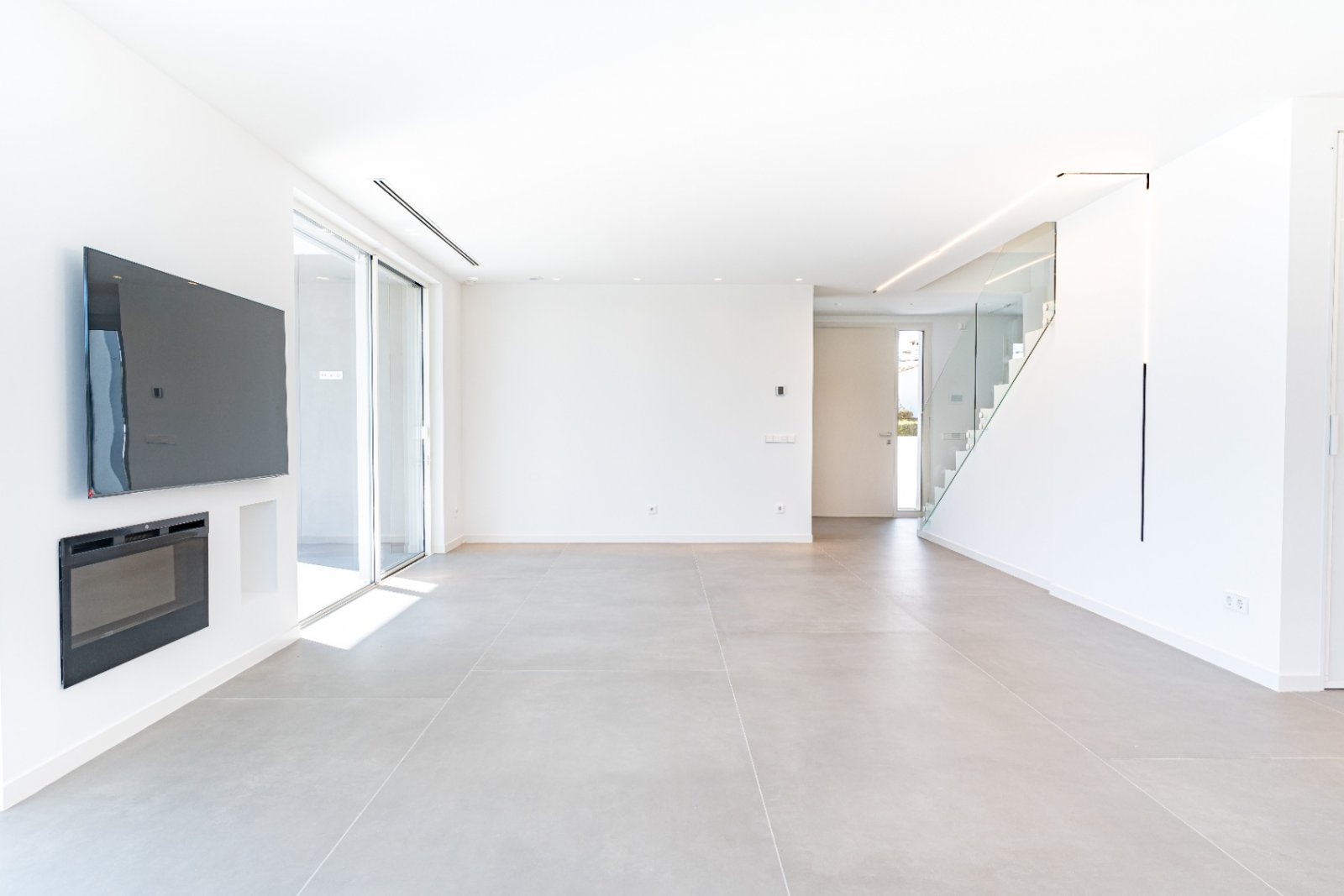 Lichtdurchfluteter Wohnbereich mit elegantem Kamin und Glastreppe - Moderne Architektur auf höchstem Niveau! Lichtdurchfluteter Wohnbereich mit elegantem Kamin und Glastreppe - Moderne Architektur auf höchstem Niveau!