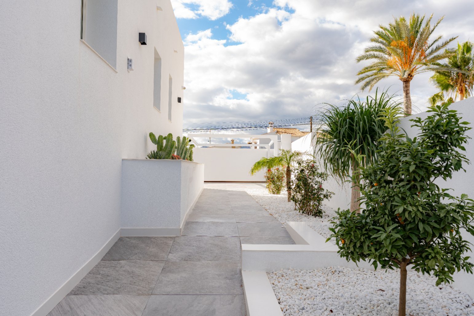 Mediterrane Gartenarchitektur: Designter Seitenweg mit pflegeleichter Bepflanzung und eleganten Natursteinelementen Mediterrane Gartenarchitektur: Designter Seitenweg mit pflegeleichter Bepflanzung und eleganten Natursteinelementen