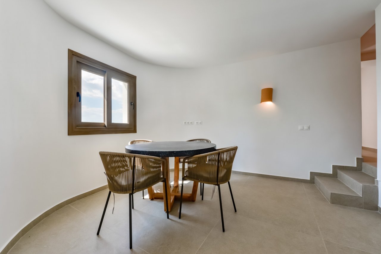 Lichtdurchfluteter Essbereich mit elegantem Naturstein-Esstisch und geschwungener Architektur Lichtdurchfluteter Essbereich mit elegantem Naturstein-Esstisch und geschwungener Architektur