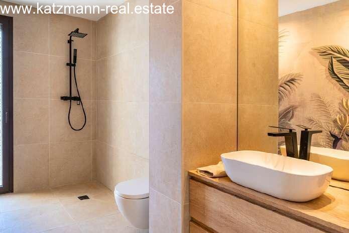 Luxuriöses Wellness-Badezimmer mit bodengleicher Regendusche und Design-Aufsatzbecken Luxuriöses Wellness-Badezimmer mit bodengleicher Regendusche und Design-Aufsatzbecken