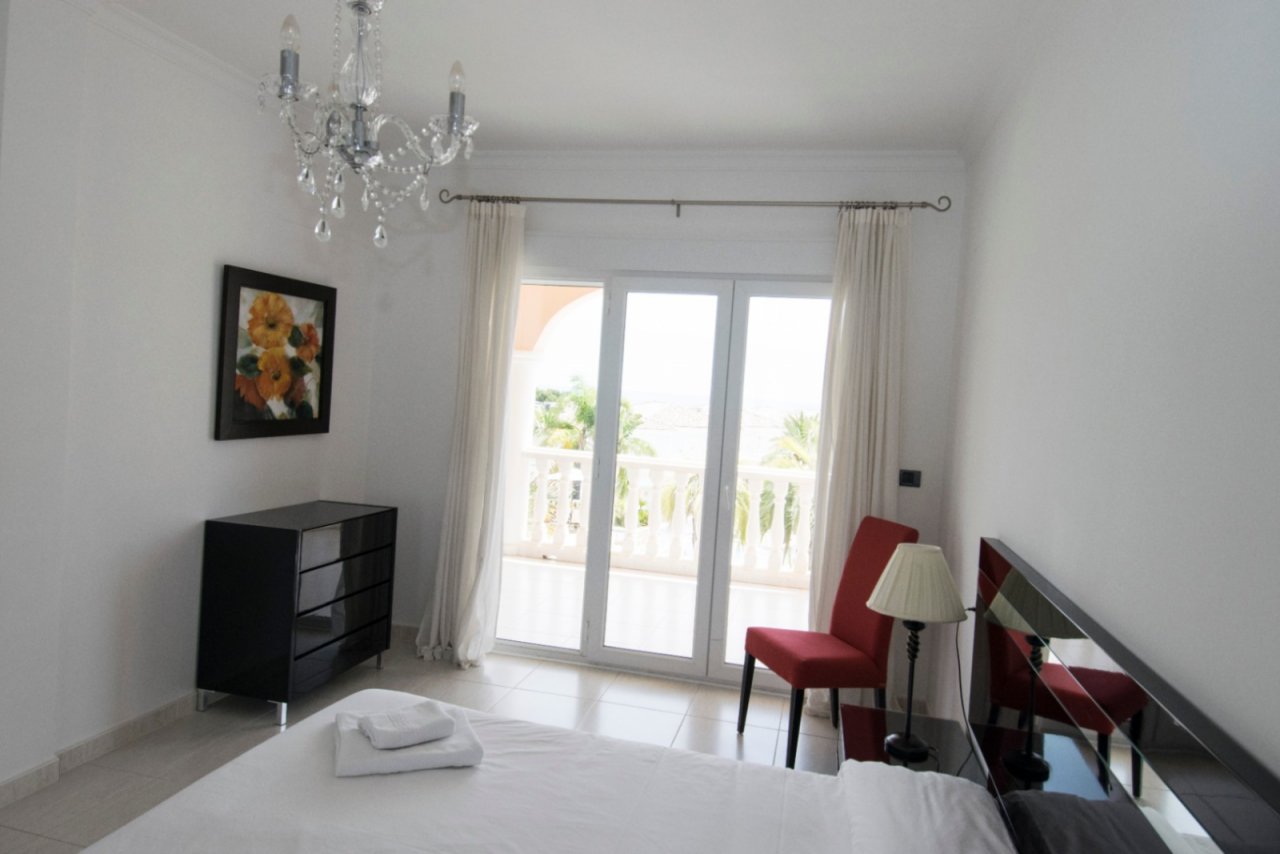 Bright bedroom with balcony access and an elegant crystal chandelier - your retreat with a view! Bright bedroom with balcony access and an elegant crystal chandelier - your retreat with a view!