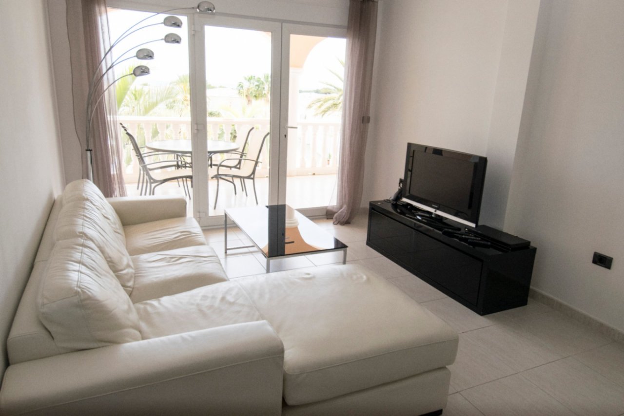 Bright living room with balcony - Modern oasis with panoramic view of palms Bright living room with balcony - Modern oasis with panoramic view of palms