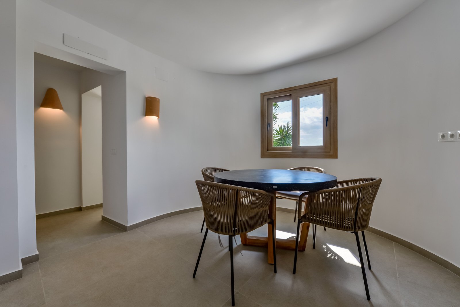 Brightly lit dining area with an elegant bay window and stylish lighting Brightly lit dining area with an elegant bay window and stylish lighting