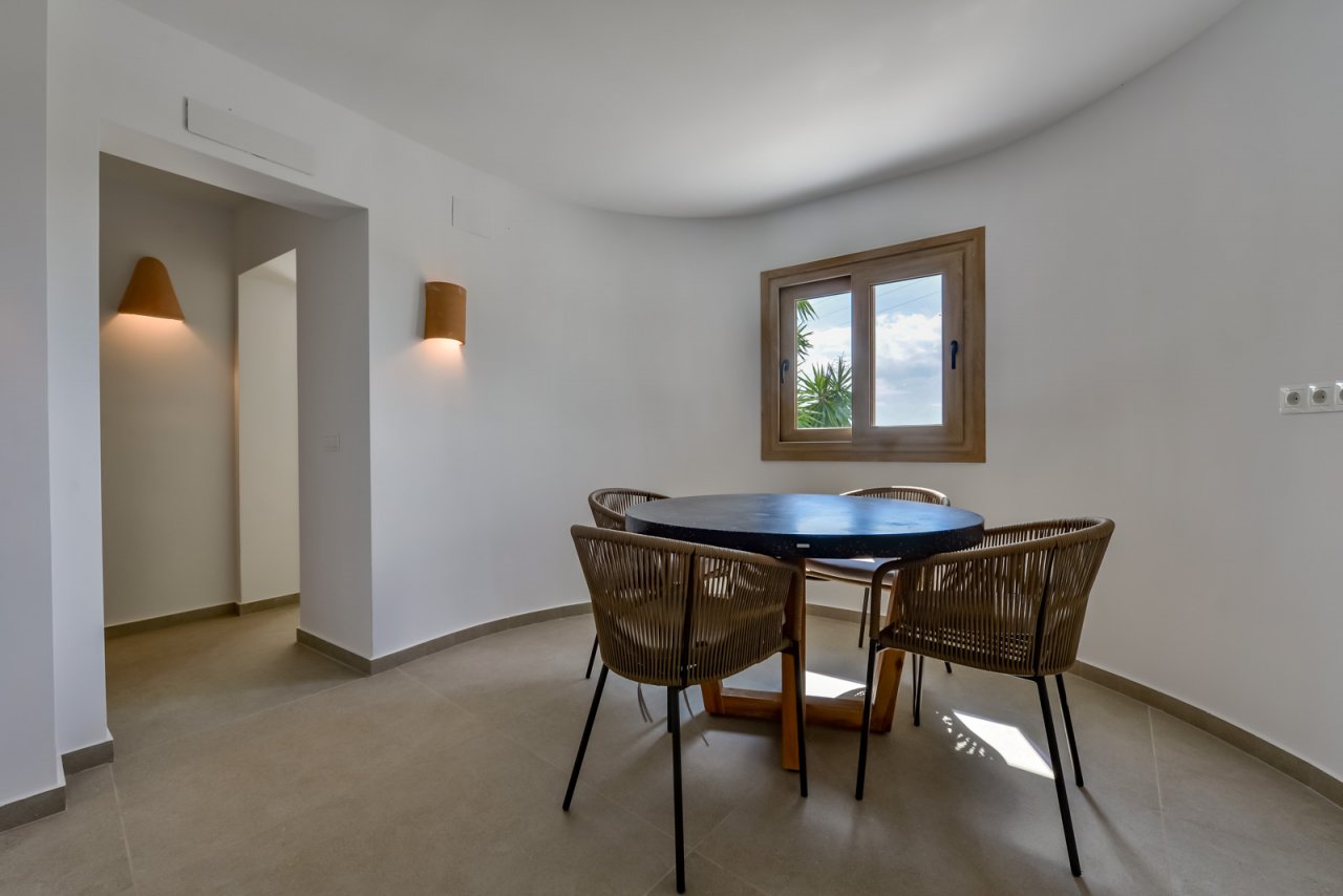 Brightly lit dining area with an elegant bay window and stylish lighting Brightly lit dining area with an elegant bay window and stylish lighting